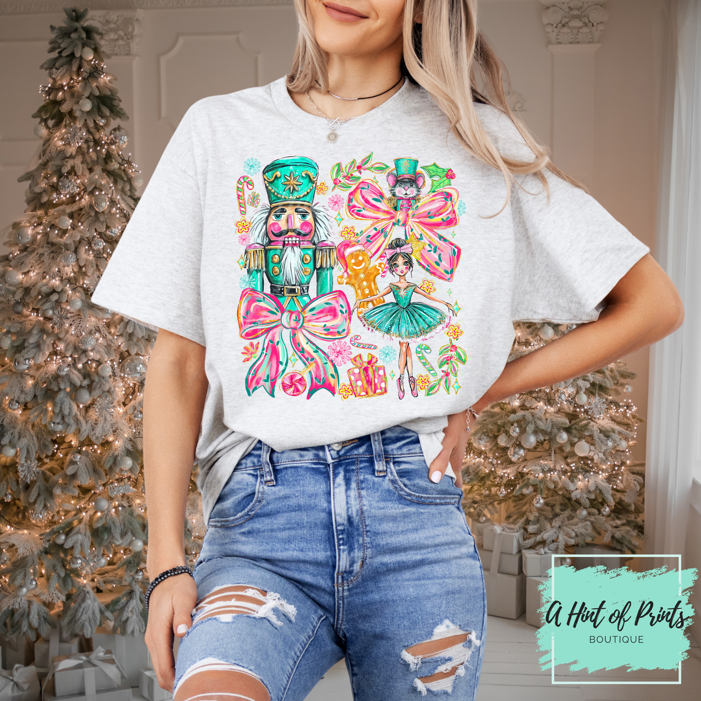 Person wearing a white t-shirt with colorful graphic design in front of a decorated Christmas tree.